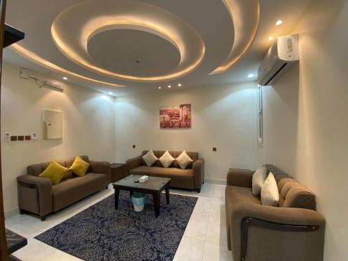 ein Wohnzimmer mit Sofas und einer runden Decke in der Unterkunft Alwan apartment hotel in Chamis Muschait
