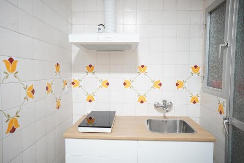 a kitchen with a sink and a white tiled wall at Bonito apartamento en primera línea de playa in Motril