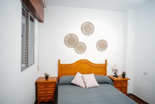 a bedroom with a bed and two night stands and a window at Bonito apartamento en primera línea de playa in Motril