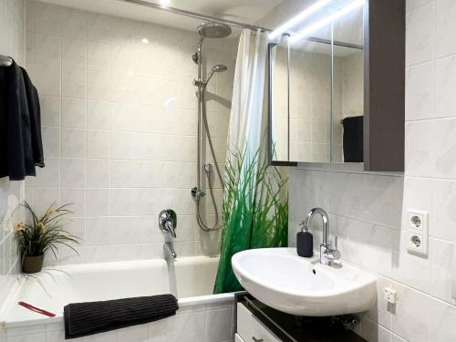 a bathroom with a sink and a shower and a tub at Moderne CityWohnung nahe Theresienwiese & Westpark in Munich