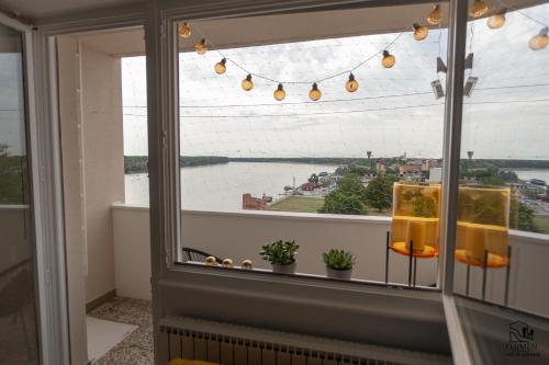 a room with a window with a view of a river at Apartman Flumen in Vukovar