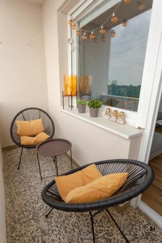 a room with two chairs and a window at Apartman Flumen in Vukovar