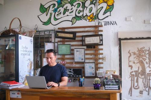 a man sitting at a table with a laptop at La Terraza Hostel in Flores
