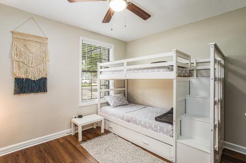 a bedroom with bunk beds and a ceiling fan at Riverside Hidden Gem W/ Triple Bunk Bed Mins to JAX DT/Riverside in Jacksonville