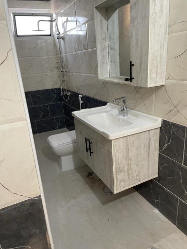a bathroom with a sink and a toilet at Poolside Perfection - Private Pool & BBQ in Irbid