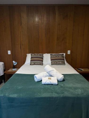 a bed with two towels on top of it at Casa da Vila - Hospedaria - 3 min do centrinho de Alter in Alter do Chao