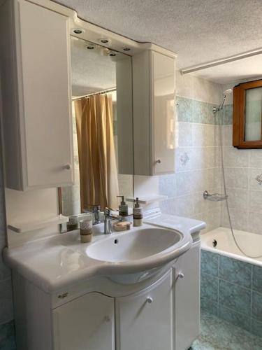 a white bathroom with a sink and a shower at Cactus villa in Karpathos Town