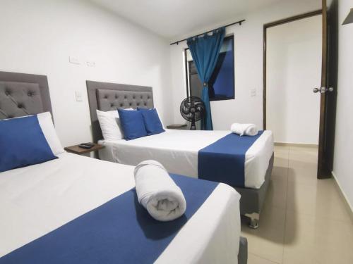 two beds in a room with blue and white at Andaliving Campo Valdes Apartamento in Medellín