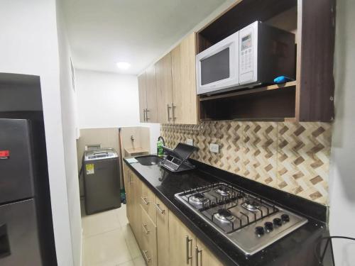a kitchen with a stove and a microwave at Andaliving Campo Valdes Apartamento in Medellín
