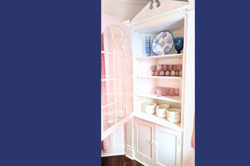 a white pantry with white cabinets and a blue plate at The Jewel of The Cove in New Haven