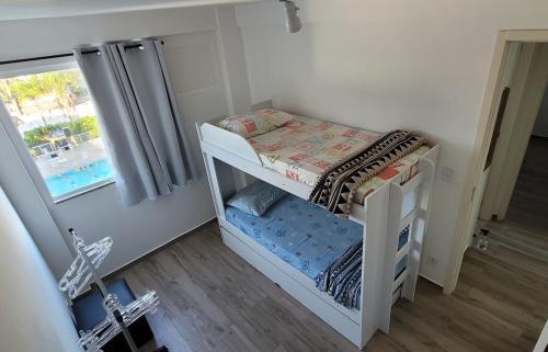 a small white bunk bed in a room with a window at Apto praia pontal, vista mar in Rio de Janeiro