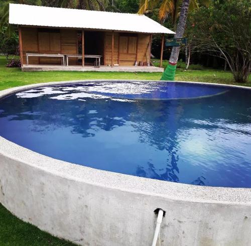 una gran piscina de agua azul frente a una casa en HOSTAL CRUZ DEL MAR, en Capurganá