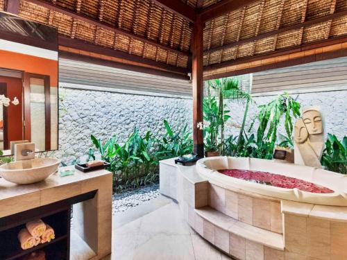 a bathroom with a bath tub in a resort at Novotel Bali Benoa in Nusa Dua