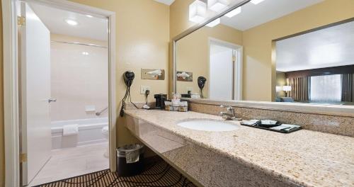 y baño con lavabo, ducha y espejo. en Best Western Gold Country Inn en Grass Valley