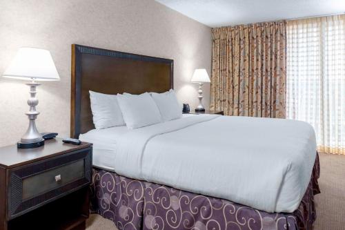 a large bed in a hotel room with two lamps at Embassy Suites by Hilton Kansas City Plaza in Kansas City