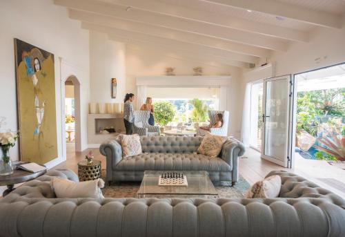 a living room with a couch and people in the background at The Retreat Costa Rica - Wellness Resort & Spa in Atenas