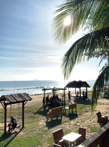 a beach with chairs and umbrellas and the ocean at Bayu Beach Penarek in Penarek