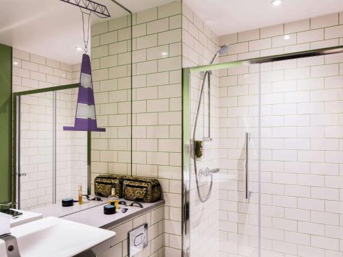La salle de bains est pourvue d'une douche et d'un lavabo. dans l'établissement ibis Styles Glasgow Centre George Square, à Glasgow