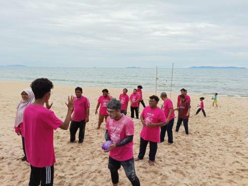 a group of people in pink shirts on the beach at Bayu Beach Penarek in Penarek