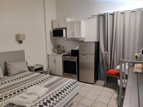 a small bedroom with a bed and a kitchen at Destination Inn Cache Creek in Cache Creek