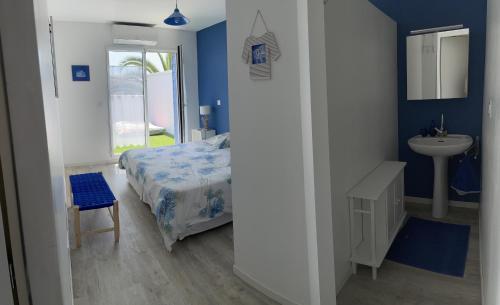 - une chambre bleue avec un lit et un lavabo dans l'établissement Idéal famille, maison neuve climatisée à 7 mn à pieds plage Minimes, à La Rochelle