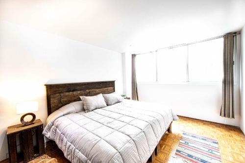 een slaapkamer met een bed en een groot raam bij Amsterdam - Deluxe Apartment with Furnished Balcony in La Condesa in Mexico-Stad