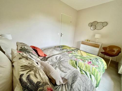 a bedroom with a bed and a dresser and a mirror at Vacances paradisiaques à la plage in Deauville