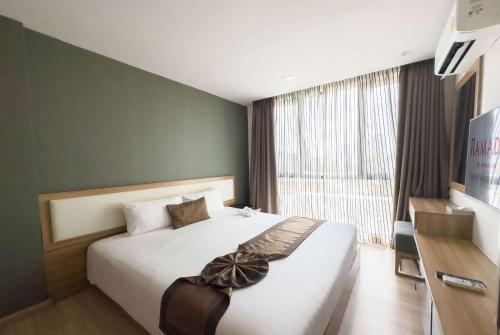 a bedroom with a bed and a large window at Ramada by Wyndham Bangkok Ten Ekamai Residences in Bangkok