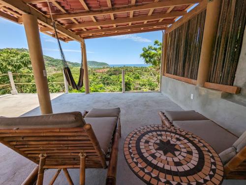 a porch with chairs and a table and a view at Casa Arcoiris Zihuatanejo B&B in Zihuatanejo