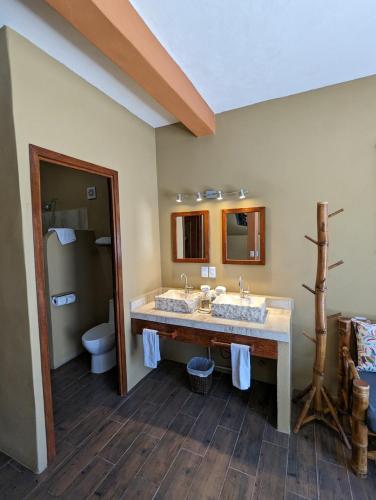 a bathroom with two sinks and a toilet at Casa Arcoiris Zihuatanejo B&B in Zihuatanejo