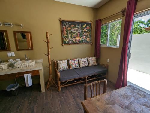 a bathroom with a bench and a sink and a table at Casa Arcoiris Zihuatanejo B&B in Zihuatanejo