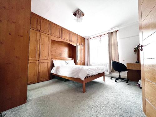 1 dormitorio con cama, escritorio y ventana en Family and Private Home en Norbury