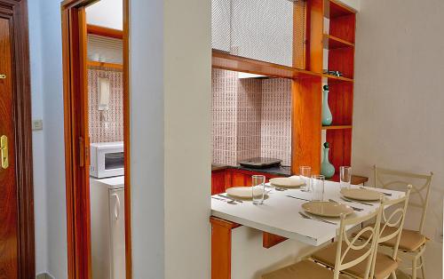 kuchnia ze stołem, krzesłami i kuchenką mikrofalową w obiekcie Apartamento Exclusivo en Sevilla w Sewilli