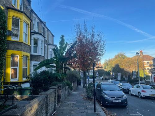 a car parked on a street next to buildings at Beautiful loft with En-Suit in a family house, in London