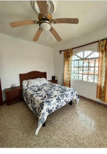 a bedroom with a bed and a ceiling fan at Hermosa casa privada con alberca. in Veracruz