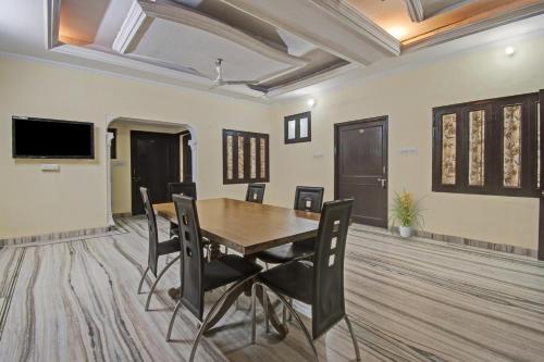 a dining room with a wooden table and chairs at Hotel O Ranak Palace in Jaipur