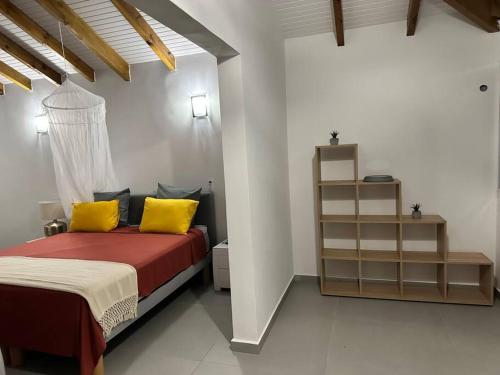 ein Schlafzimmer mit einem Bett mit zwei gelben Kissen in der Unterkunft VILLA JASMIN : EXCEPTIONNELLE !! in Petit-Bourg