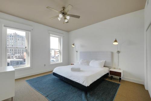 a white bedroom with a bed and two windows at 2br Apartment With King Beds, Historic Charm in Louisville