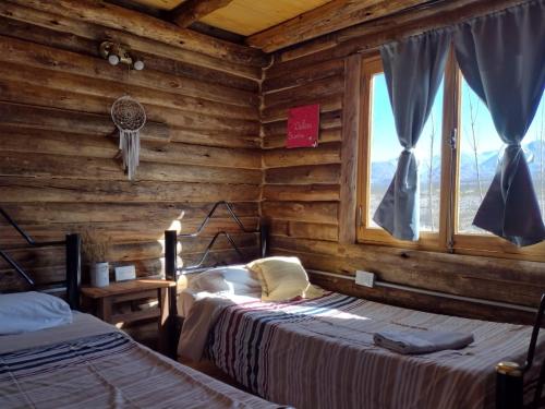 1 dormitorio con 2 camas en una cabaña de madera en cabañas de montaña en Uspallata
