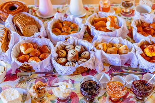 a table with many different types of pastries in baskets at Pousada Alemã in Santo Antônio do Pinhal