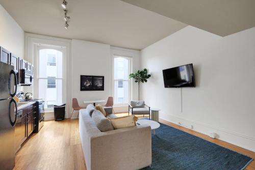 a living room with a couch and a tv on a wall at Historic Charm, Walkable Entertainment in Louisville