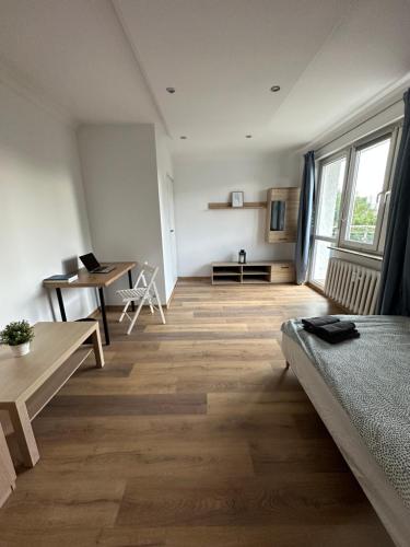 a room with a bed and a desk and a table at Rooms4Less in Gdańsk
