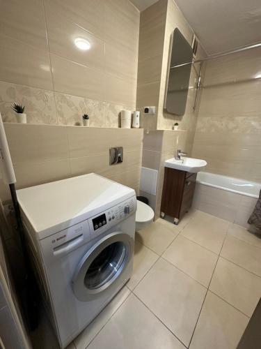 a bathroom with a washing machine and a sink at Rooms4Less in Gdańsk