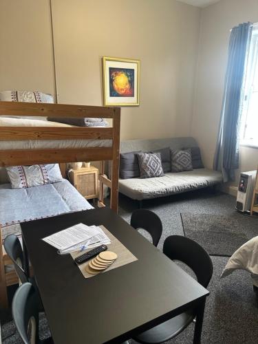 Zimmer mit einem Tisch, Stühlen und einem Etagenbett in der Unterkunft Cooma Hotel in Cooma