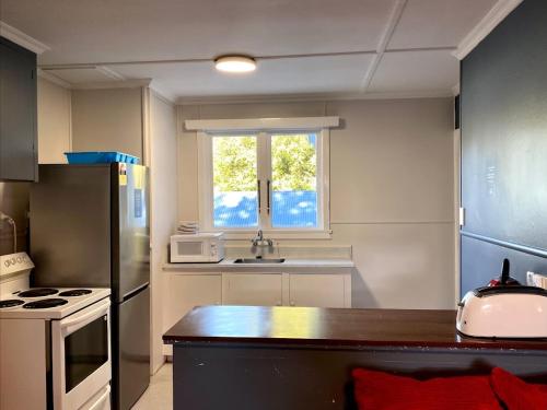 a kitchen with a counter and a window in it at Pinewood Lodge and Apartments in Queenstown