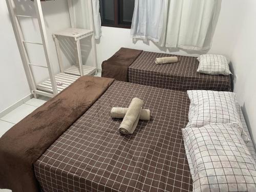 two beds in a small room with two at Condomínio Canto das Orquídeas VI in Porto Seguro