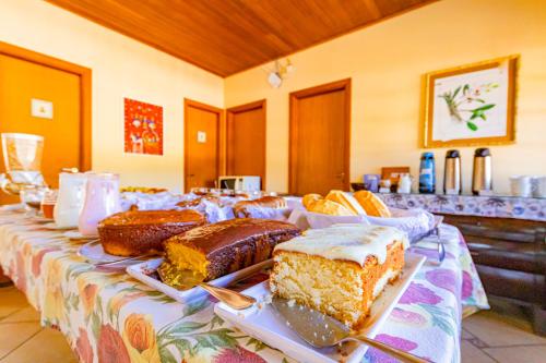 a table topped with cakes and pastries on a table at Pousada Alemã in Santo Antônio do Pinhal