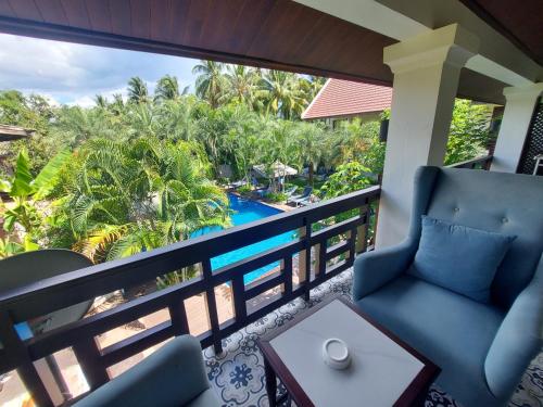 a balcony with chairs and a view of a pool at Sunrise Garden House - Luang Prabang in Luang Prabang