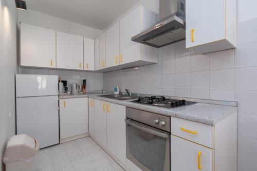 a kitchen with white cabinets and a stove top oven at Apartments with a parking space Crikvenica - 5494 in Crikvenica