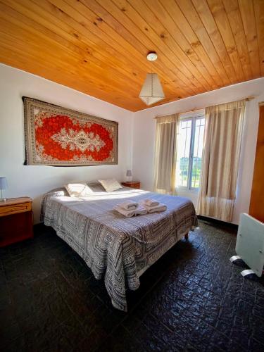 a bedroom with a bed and a wooden ceiling at Cabañas Los Pioneros in Tandil
